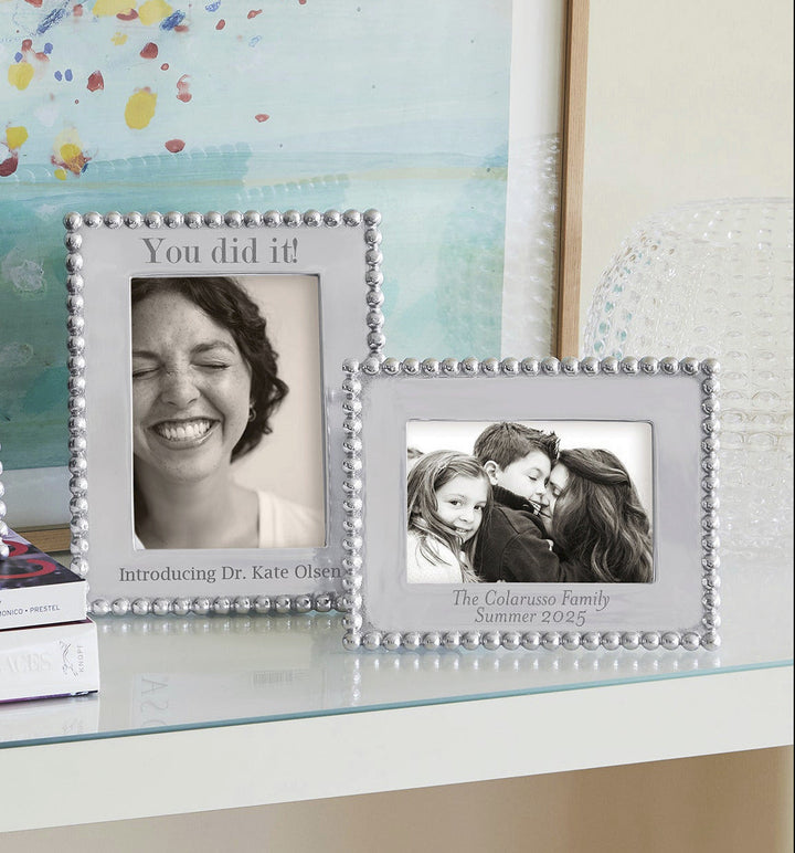 Silver beaded photo frame with two pictures on a desk