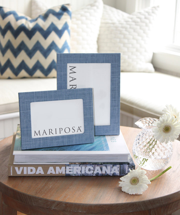 Textile frame on table with decorative vase and books