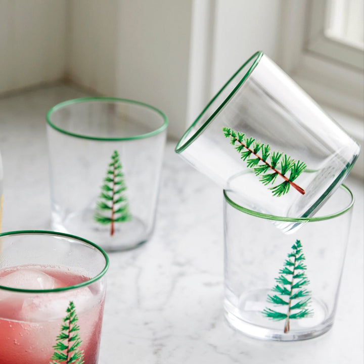 Clear glasses with green tree designs on a marble surface